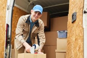 Paketbote schaut kurz von der Arbeit auf und lächelt